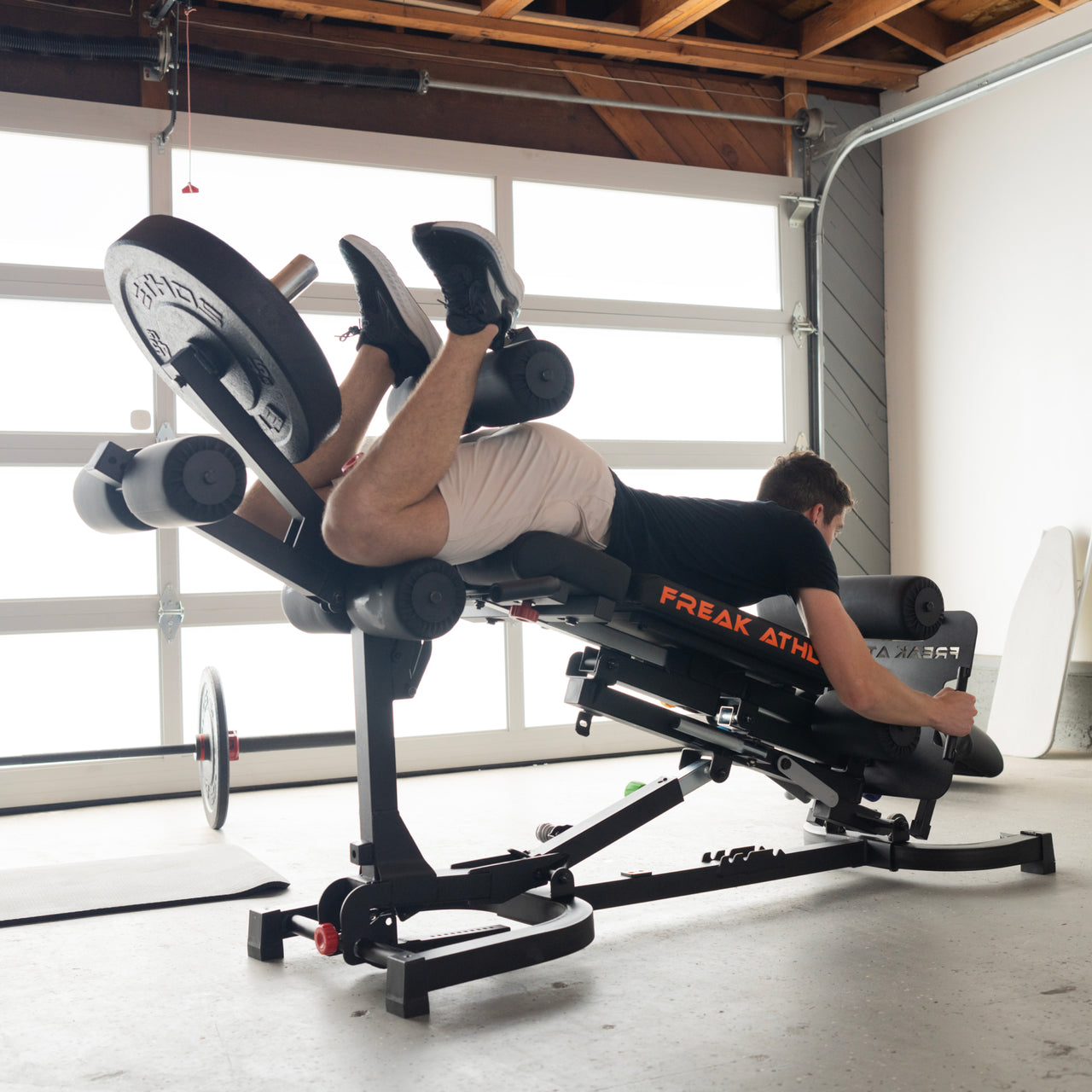 Man using exercise equipment in a home gym setting.